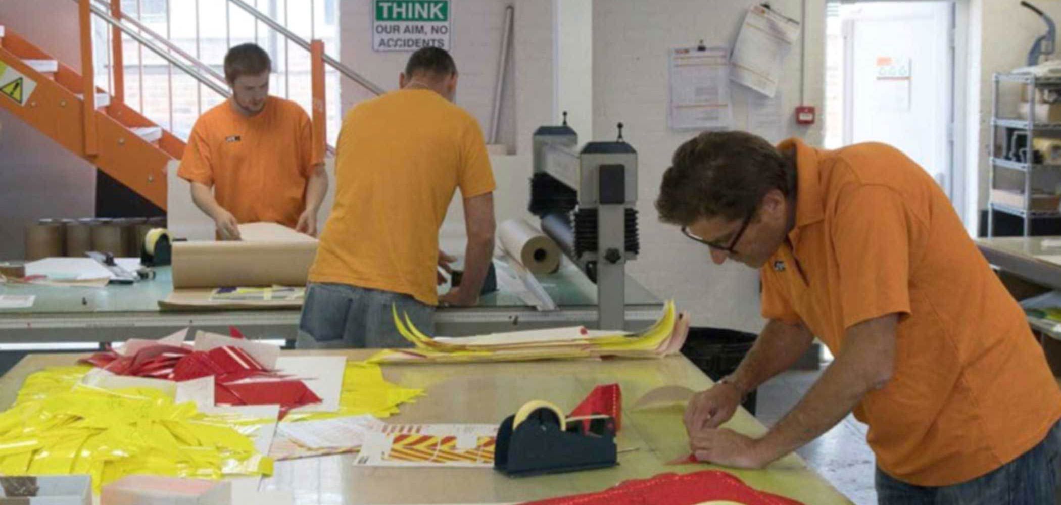 The PVL workshop with staff preparing vinyl cutouts